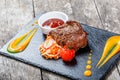 Grilled beef steak with fresh salad and bbq sauce on stone slate background on wooden background Royalty Free Stock Photo