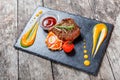 Grilled beef steak with fresh salad and bbq sauce on stone slate background on wooden background Royalty Free Stock Photo