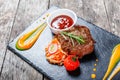 Grilled beef steak with fresh salad and bbq sauce on stone slate background on wooden background Royalty Free Stock Photo