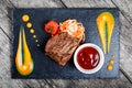 Grilled beef steak with fresh salad and bbq sauce on stone slate background on wooden background Royalty Free Stock Photo