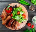 Grilled Beef steak with fresh vegetable salad, tomatoes and sauce on wooden cutting board. Royalty Free Stock Photo