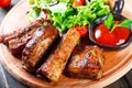 Grilled Beef steak with fresh vegetable salad, tomatoes and sauce on wooden cutting board Royalty Free Stock Photo