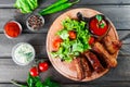 Grilled Beef steak with fresh vegetable salad, tomatoes and sauce on wooden cutting board Royalty Free Stock Photo