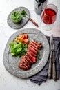 Grilled beef steak medium rare slices on gray stone plate with salad and chimichurri sauce Royalty Free Stock Photo