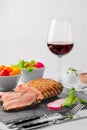 Grilled beef steak medium rare on stone board with fresh vegetables and glass of red wine. Royalty Free Stock Photo