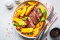 Grilled beef steak with potatoes and basil in a white plate, top view Royalty Free Stock Photo