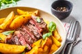 Grilled beef steak with potatoes and basil in a white plate on white background Royalty Free Stock Photo