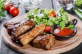 Grilled Beef steak Ribeye with fresh vegetable salad, tomatoes and sauce on wooden cutting board. Royalty Free Stock Photo