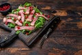 Grilled Beef Steak salad with arugula, pomegranate and greens vegetables. Dark wooden background. Top view. Copy space Royalty Free Stock Photo