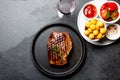 Grilled beef steak served on cast iron plate with tomato salad, potatoes balls and red wine. Barbecue, bbq meat beef Royalty Free Stock Photo