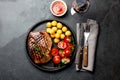 Grilled beef steak served on cast iron plate with tomato salad, potatoes balls and red wine. Barbecue, bbq meat beef Royalty Free Stock Photo