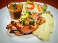 Grilled beef steak sirloin with gravy sauce in small glass, mashed potatoes and vegetable salad on white dish Royalty Free Stock Photo