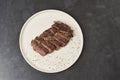 Grilled beef steak with spices on a white tray, close-up