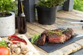 Grilled beef steak on wooden table top. Healthy food concept. Beef cut outdoors, garden kitchen, bbq grill patio Royalty Free Stock Photo