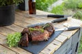 Grilled beef steak on wooden table top. Healthy food concept. Beef cut outdoors, garden kitchen, bbq grill patio Royalty Free Stock Photo