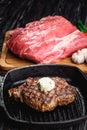 Grilled Black Angus Steak on grill iron pan on wooden black background with raw Royalty Free Stock Photo