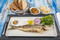 Grilled bluefish fish platter. Bluefish and appetizers in white plate