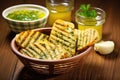grilled bread in a basket, garlic herb butter in a bowl