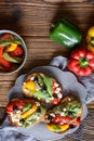 Grilled bread slices topped with baked red, green and yellow bell pepper, black olives, arugula and Feta cheese Royalty Free Stock Photo