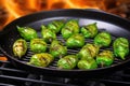 grilled brussels sprouts in a shiny grill wok