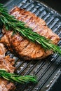 Grilled buffalo beef steak with rosemary in black grill pan on the table, close-up Royalty Free Stock Photo