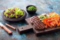 Grilled burger cutlets with baked sweet potato, vegetables and salad served on wood chopping board Royalty Free Stock Photo