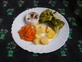 Grilled camembert with chilli on white plate with potatoes, carrots and broccoli