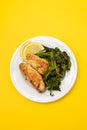Grilled caviar cod fish with greens and fresh lemon on white small plate. Royalty Free Stock Photo
