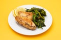 Grilled caviar cod fish with greens and fresh lemon on white small plate. Royalty Free Stock Photo