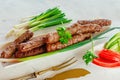 Grilled Cevapcici is a Balkan national dish. Close the row of fried beef kebabs on a white rectangular dish with vegetables Royalty Free Stock Photo