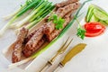 Grilled Cevapcici is a Balkan national dish. Close the row of fried beef kebabs on a white rectangular dish with vegetables Royalty Free Stock Photo