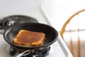 Grilled cheese cooking on stove top pan Royalty Free Stock Photo