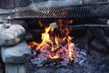 Grilled cheese. Frying piece of cheese on special wooden spiked stick. Wonderful flame with cinders. Black grate for meat