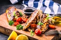 Grilled chicken breast in different variations with cherry tomatoes, mushrooms, herbs, cut lemon on a wooden board or teflon pan. Royalty Free Stock Photo