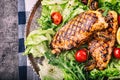 Grilled chicken breast in different variations with lettuce salad cherry tomatoes mushrooms herbs cut lemon on a wooden board or Royalty Free Stock Photo