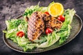 Grilled chicken breast in different variations with lettuce salad cherry tomatoes mushrooms herbs cut lemon on a wooden board or Royalty Free Stock Photo