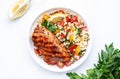 Grilled chicken breast fillet with tabbouleh salad with bulgur, tomato and parsley with lemon dressing, white table background,