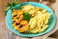 Grilled chicken breast and Penne pasta with spices and Basil. A delicious dinner in the rustic style. Selective focus Royalty Free Stock Photo