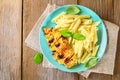 Grilled chicken breast and Penne pasta with spices and Basil. A delicious dinner in the rustic style. Selective focus Royalty Free Stock Photo