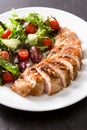 Grilled chicken breast with vegetables on a plate on black background Royalty Free Stock Photo