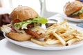 Grilled Chicken Burger with Ham and Cheese and French Fries Royalty Free Stock Photo