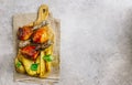 Grilled chicken drumstick bbq with potato slices on a cutting board on a stone gray background Royalty Free Stock Photo