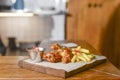 Grilled chicken drumstick, deep fried chicken legs, french fries and sauce. Served on a wooden board in restaurant Royalty Free Stock Photo