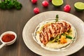 Grilled chicken fillet is cut into slices on a cushion of mashed potatoes with vegetables - onion, garlic, pepper, cabbage, radish Royalty Free Stock Photo