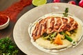 Grilled chicken fillet is cut into slices on a cushion of mashed potatoes with vegetables - onion, garlic, pepper, cabbage, radish Royalty Free Stock Photo