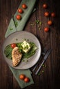 Grilled chicken fillet with mashed potatoes and green peas. Green tablecloth, dark woody background. Top view