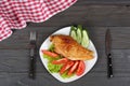 grilled chicken fillet on white plate with tomato on dark wooden background with red cloth. With copy space. Top view Royalty Free Stock Photo