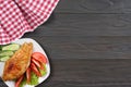 Grilled chicken fillet on white plate with tomato on dark wooden background with red cloth. With copy space. Top view Royalty Free Stock Photo