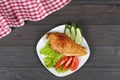 grilled chicken fillet on white plate with tomato on dark wooden background with red cloth. With copy space. Top view Royalty Free Stock Photo