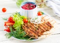 Grilled chicken kebab with beet hummus and pita, fresh vegetables on a white table. Royalty Free Stock Photo